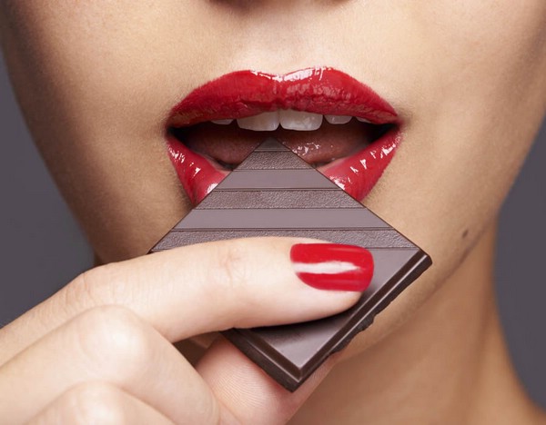 Сексуальная девушка ест шоколад